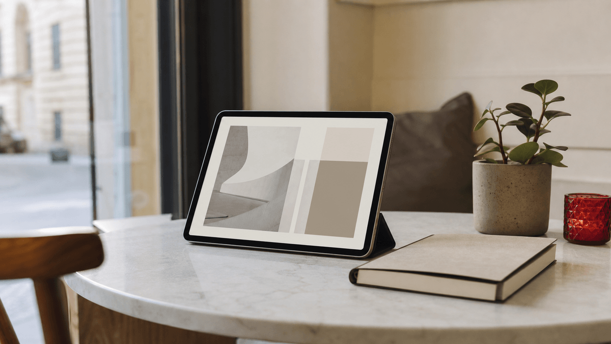 A calm minimalist single-page business website shown on a tablet propped on a clean cafe-style table next to a plant and a notebook, no people, quiet uncluttered feel, soft natural light, photorealistic, no text